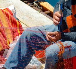 fisherman repairs the fishing net