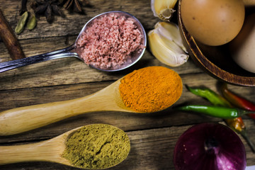 Close up of various asian spices and other common kitchen ingredients on wooden board.