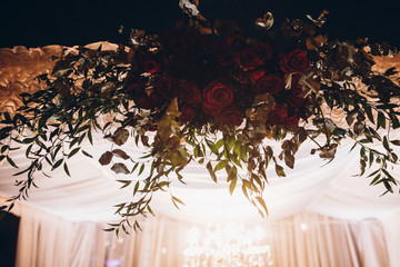 white and red arch and aisle at wedding reception in park, with red bouquet et evening ceremony in...