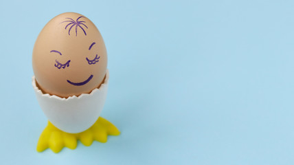 White chicken egg sleeping with happy face on the blue background