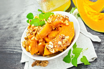 Pumpkin with nuts and honey on dark wooden board