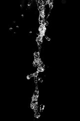 Fototapeta na wymiar water jet with splashes on a black background