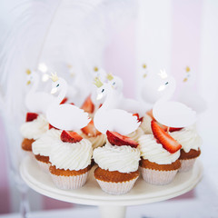 Tasty cupcakes on stand. Swan shaped topper for cupcakes. Ballerina children birthday party.  Catering buffet for events. 