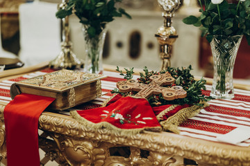 golden bible and cross on altar  in church. traditional wedding ceremony, space for text. religion