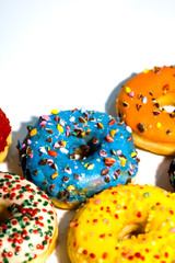 Sweet tasty donuts with colorful sprinkles isolated on white background