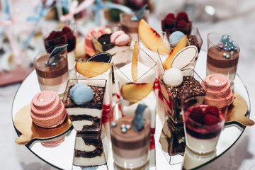 luxury wedding catering, table with modern desserts, cupcakes, sweets with fruits. delicious candy bar at expensive wedding reception. space for text. shower. holiday celebration