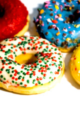Sweet tasty donuts with colorful sprinkles isolated on white background