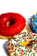 Sweet tasty donuts with colorful sprinkles isolated on white background