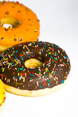 Sweet tasty donuts with colorful sprinkles isolated on white background