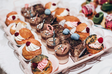 luxury wedding catering, table with modern desserts, cupcakes, sweets with fruits. delicious candy bar at expensive wedding reception. space for text. shower. holiday celebration