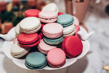 delicious macaroons. candy bar at luxury wedding reception. exclusive expensive catering. table with modern desserts. space for text. baby or bridal shower. holiday celebration
