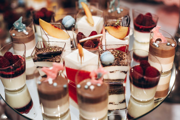 delicious candy bar at luxury  wedding reception. exclusive expensive catering. table with modern...