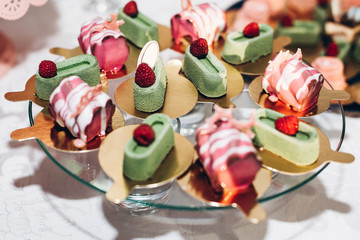 delicious candy bar at luxury  wedding reception. exclusive expensive catering. table with modern desserts, cupcakes, sweets with fruits. space for text. baby or bridal shower. holiday celebration