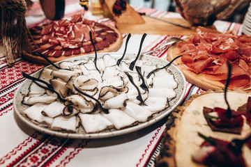 lard on table at luxury wedding reception. ham,bacon,sausages,salami,prosciutto,lard on wooden desk. expensive catering at celebration, birthday, shower, christmas. space for text