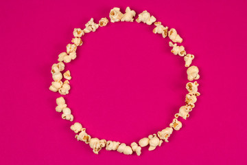 top view food fashion flat lay popcorn circle frame with copy space on a pink background
