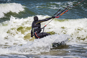 Fototapeta premium Kitesurfer in the waves of the Baltic sea. Curonian Spit, Russia