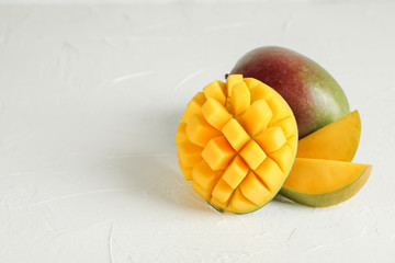 Cut ripe mangoes and space for text on white background, closeup