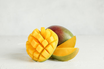 Cut ripe mangoes and space for text on white background, closeup