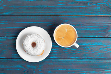 fresh donut with coffee on wooden surface, top view
