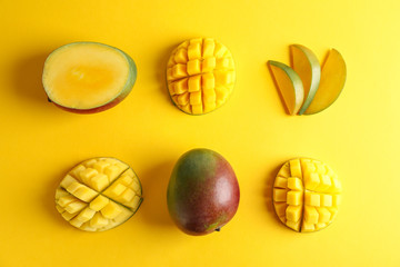 Flat lay composition with ripe mangoes on color background