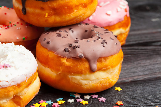 Glazed colored donuts background image. Macro shot