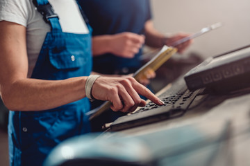 Quality Control Process Inspector monitoring CNC machine operator