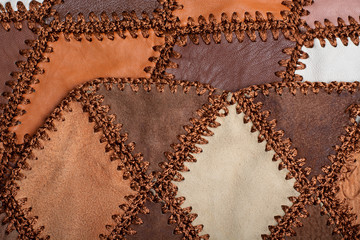 Pieces of multi-colored leather stitched with thread. The front and back side, suede. Leather texture, background, haberdashery, sew clothes and bag.