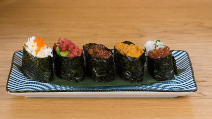 different varieties of gunkan wrapped in nori seaweed, bluefin tuna tartare, caviar of different sizes and colours avocado, sea urchin and squid