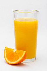 a glass of orange juice and a slice of orange on a white background