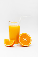 glass of orange juice and sliced orange on a white background