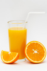 glass of orange juice and sliced orange on a white background