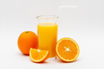 glass of orange juice and oranges on a white background