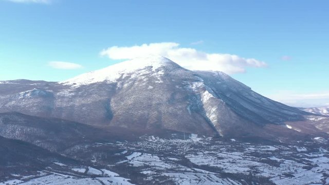 Clouds over the top of snowed Rtanj mountain 4K drone video