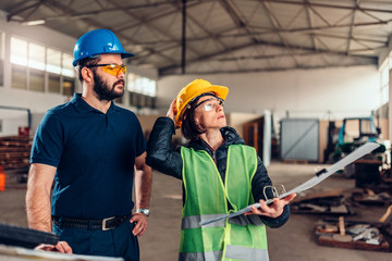 Workplace safety inspector writing a report at industrial factory