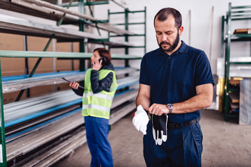 Warehouse worker putting on protective gloves