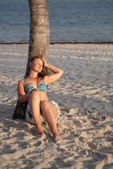 Young girl in bikini on the palm tree