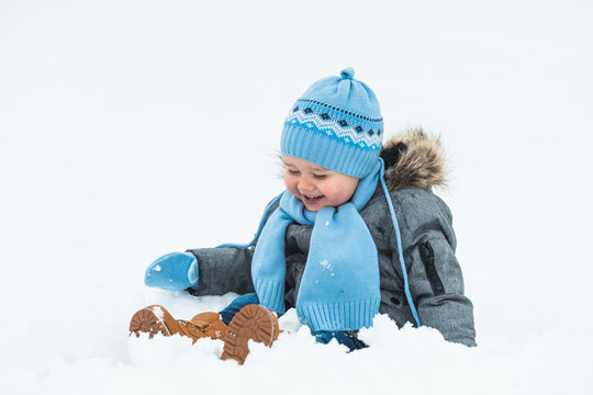 Smiling baby boy playing in the snow