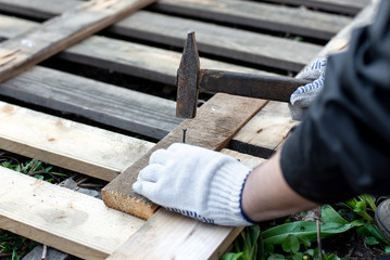 nails, hammer, nail in the board. the carpenter works the dacha