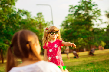 Naklejka premium Young mother and little daughter playing in park with soap bubbles. Love family, parenthood, childhood