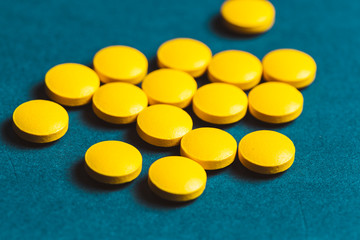 close up of yellow pills on a blue background