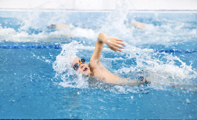 Fototapeta na wymiar little boy swimming in pool