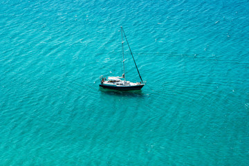 Yacht sailing in open transparent blue sea