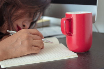 Fototapeta na wymiar very sleepy and tired business woman on desktop computer, red coffee mug.