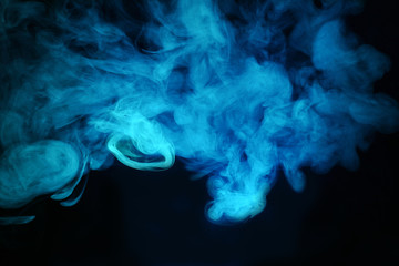 Bright colored smoke rises on a black background.