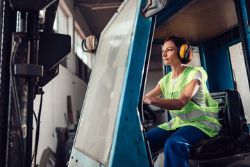 Woman forklift operator driving vehicle © kerkezz
