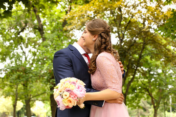 Happy beautiful engaged couple posing outdoor in park