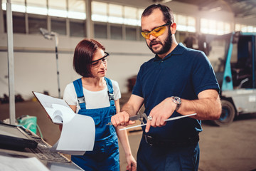 Female CNC Machine Operator measuring cut out product