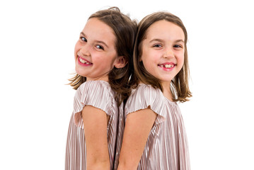 Identical twin girls are turned facing back to back.