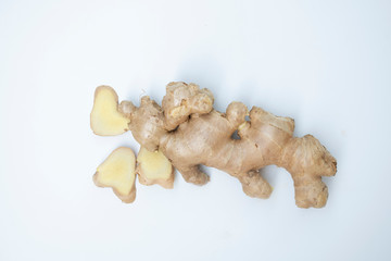 fresh ginger root closeup view, Thick tuberous vegetable with brown skin and pale yellow flesh, top view on white background.