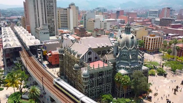 Beautiful aerial shot of metro train passing Botero square while entering station in sunny day
